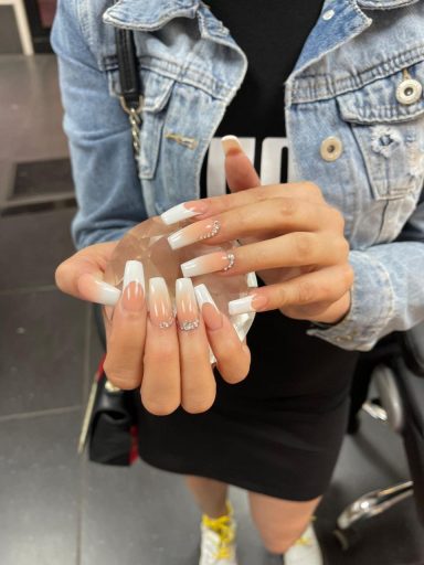 Een hand met lange, verzorgde nagels die een doorzichtige bol vasthoudt.