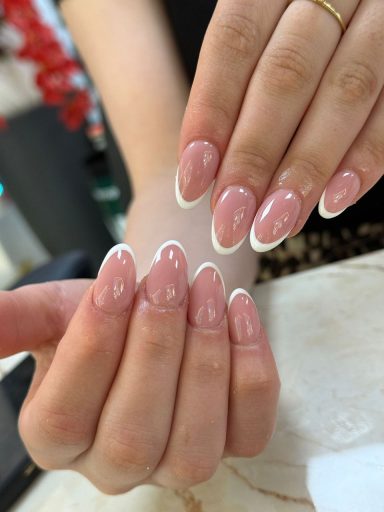Natuurlijk gevormde, lichtroze nagels met een witte rand.