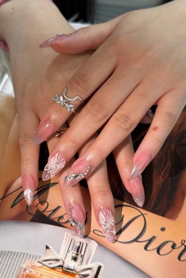 Gestylde handen met lange nagels en een ring, liggen op een tijdschrift.