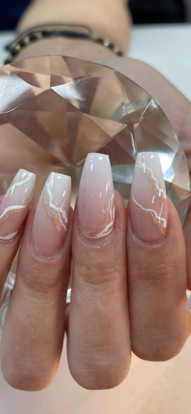 Hand met langere, lichtroze nagels met een glanzende afwerking en marmerpatroon.