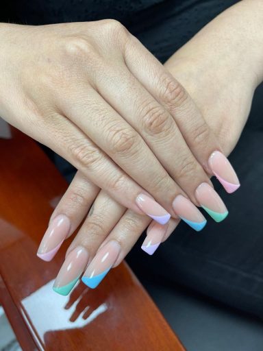 Vijf handen met lange, gekleurde nagels in pastelkleuren en een nette manicure.
