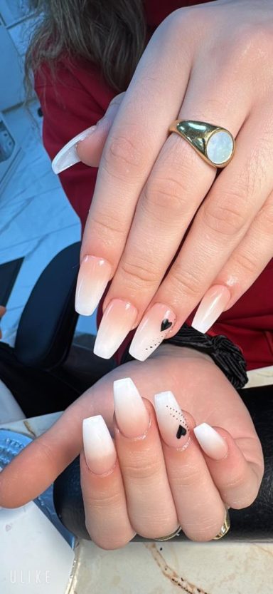 Gekleurde nagels met een wit omhulsel en een ring op een hand.